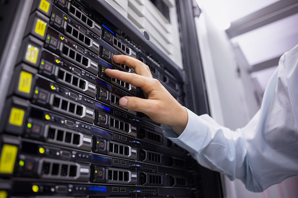 Technician working on server tower in large data center